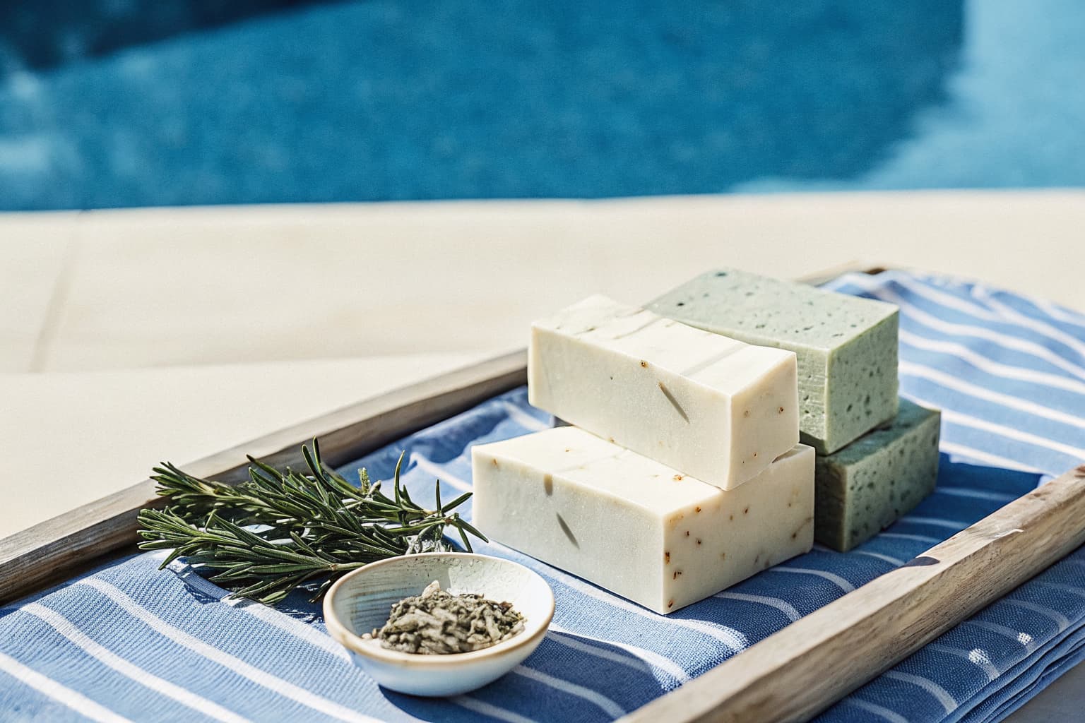 Handmade natural soap bars on a wooden tray with herbs